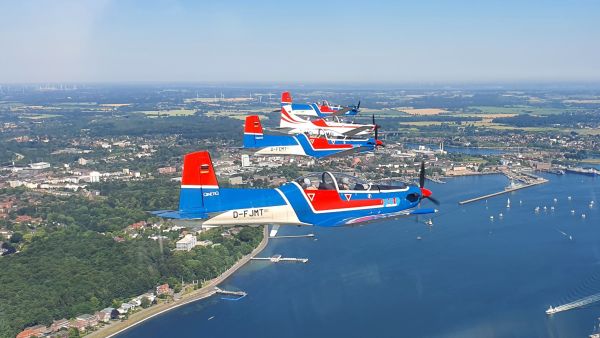 Luftbild mit 4 PC9-Maschinen im Formationsflug