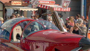 Rotes Flugzeug vor der Menschenmenge, die den Flughafen besucht