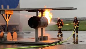 Zwei Feuerwehrleute spritzen Wasser auf eine brennende Turbine