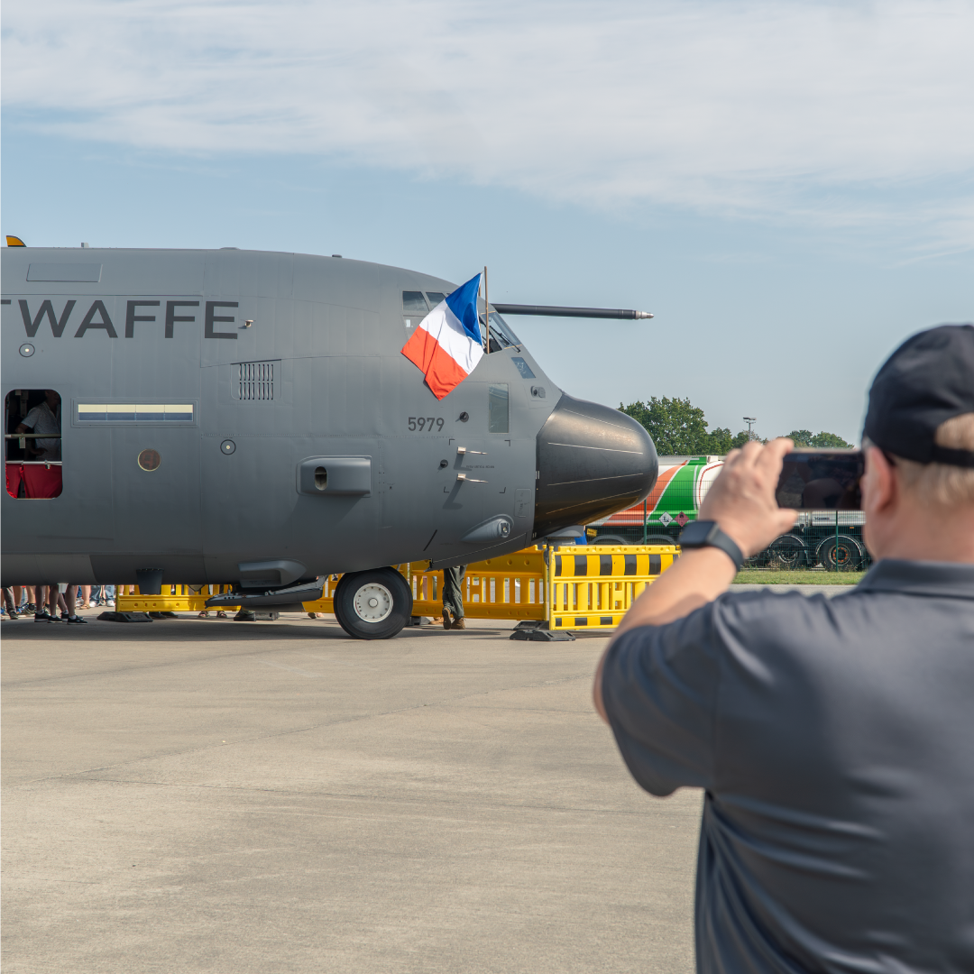 Man taking a picture of C130 aircraft