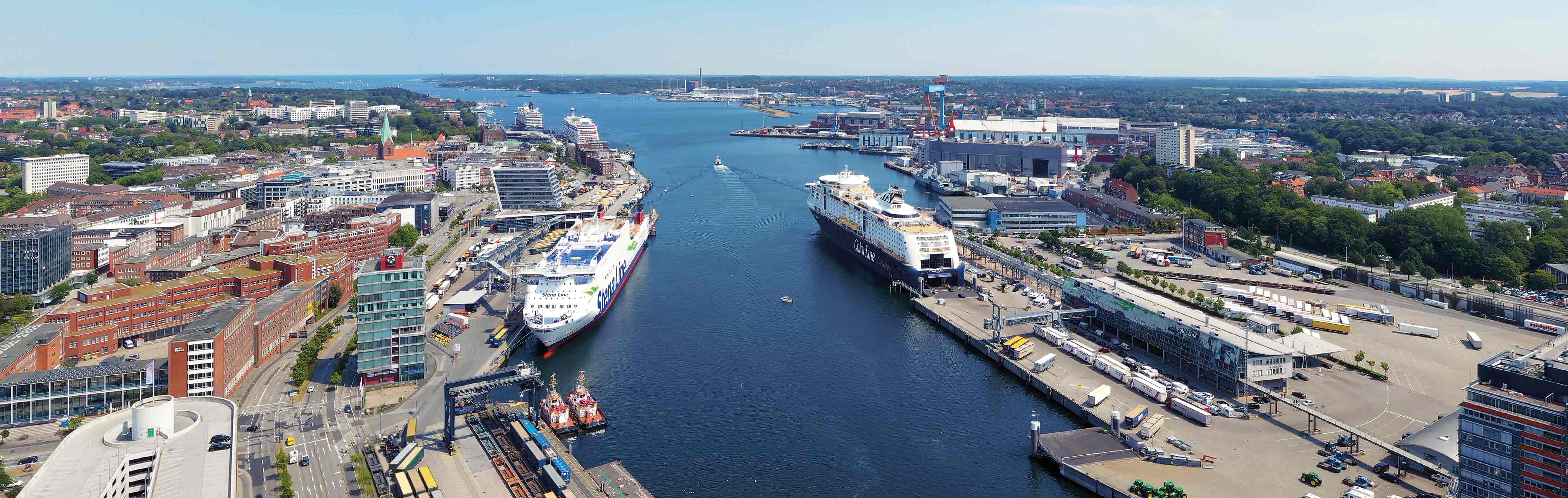 Man sieht den Blick von der Innenstadt über die Hafenteile des PORT KIEL als Luftbild.